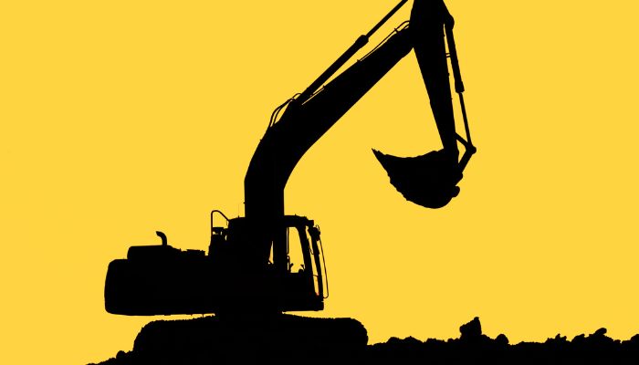 Excavator digging into the ground, yellow background