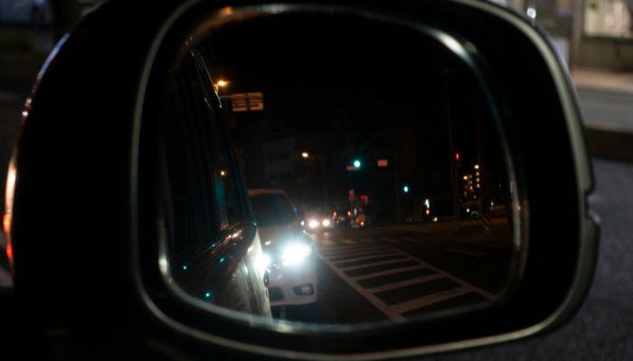Checking car mirror for vehicles that are following behind discreetly