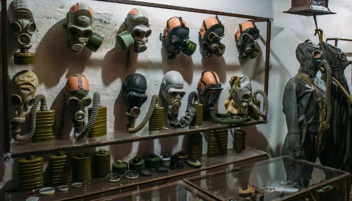 A storage room inside an underground bunker that houses a variety of gas masks and radiation gear
