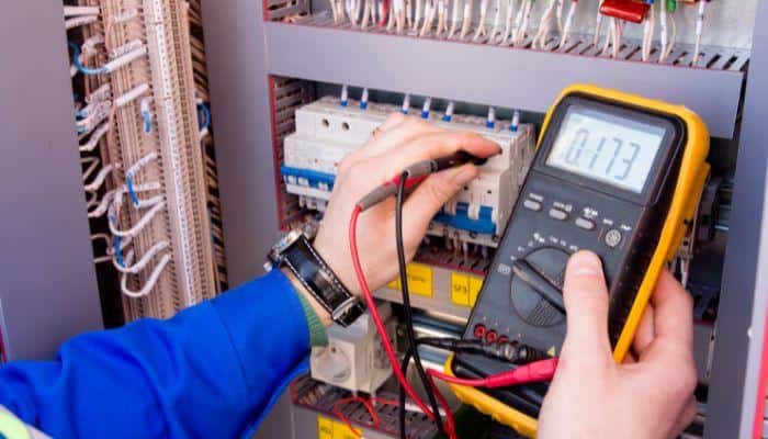 Electrician using a multimeter to monitor Voltage inside a cheap DIY underground bunker