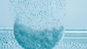 Water purification tablet being dissolved into a glass of water, fizzing away into bubbles as it purifies the water inside.